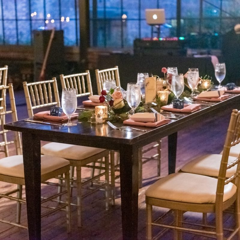 A high angle shot of a table with an elegant setting in the restaurant hall in the evening